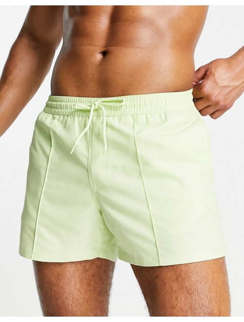 ASOS DESIGN swim shorts with curved hem in lime green short length