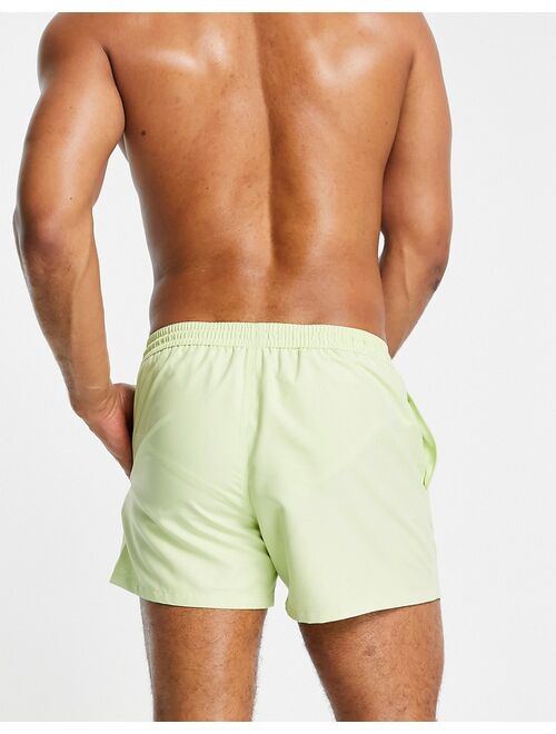 ASOS DESIGN swim shorts with curved hem in lime green short length