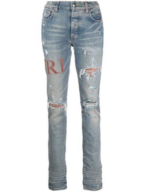 AMIRI logo-embellished distressed jeans