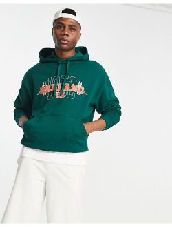 oversized hoodie in dark green with varsity Oakland print