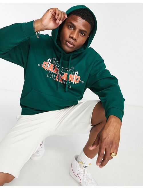 ASOS DESIGN oversized hoodie in dark green with varsity Oakland print