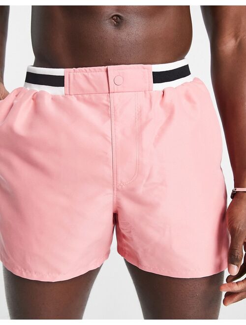 ASOS DESIGN swim shorts in short length with smart styling and contrast rib in pink