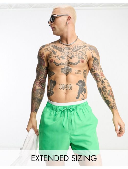 ASOS DESIGN swim shorts in short length with contrast waistband in green