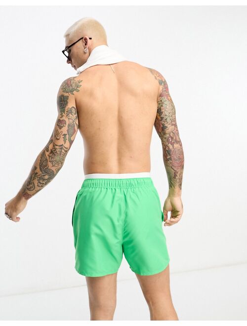 ASOS DESIGN swim shorts in short length with contrast waistband in green