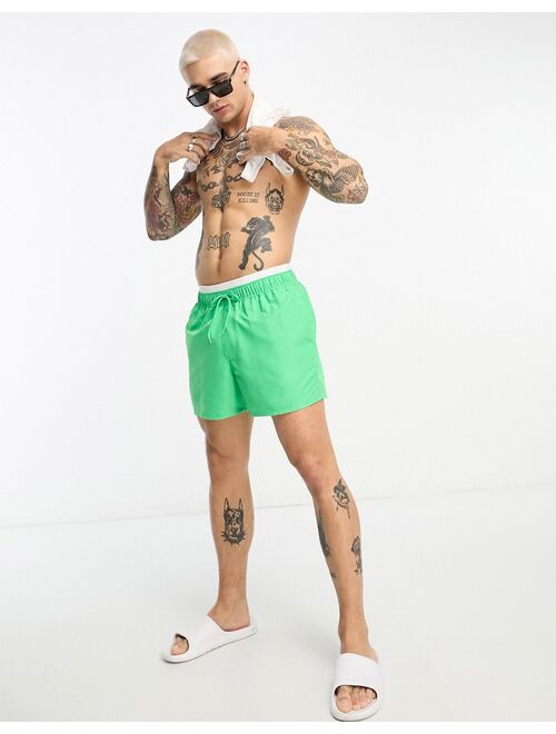 ASOS DESIGN swim shorts in short length with contrast waistband in green