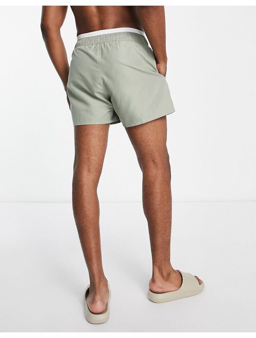 ASOS DESIGN swim shorts in short length with double waistband in light green