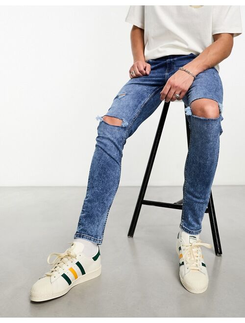 ASOS DESIGN skinny jeans with knee rips in mid wash blue