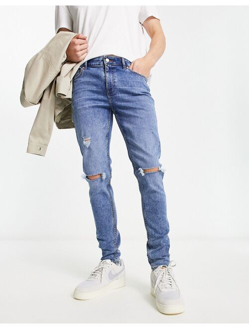 ASOS DESIGN skinny jeans in mid wash blue with rips