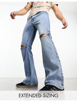 flare jeans with open knees in mid wash blue